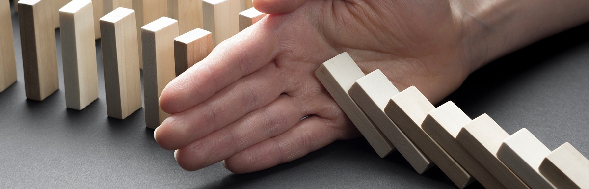 倒れるドミノを支える手