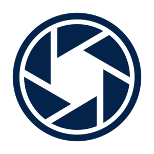 A dark blue icon depicting a camera shutter, consisting of five triangular segments arranged in a circular pattern, symbolizing photography or camera technology. 