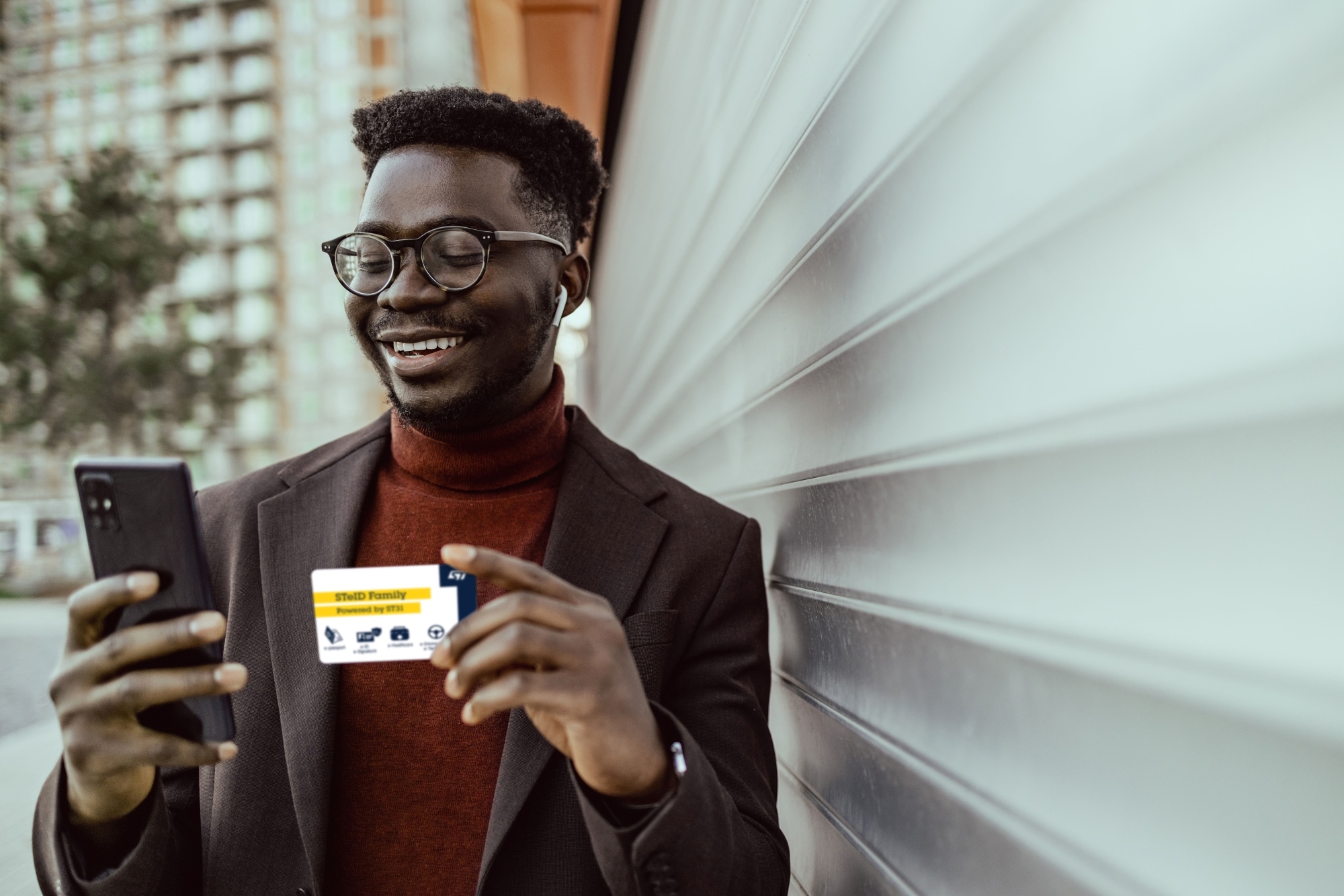 Person holding a smartphone in one hand and a credit card in the other, appearing to make an online payment.