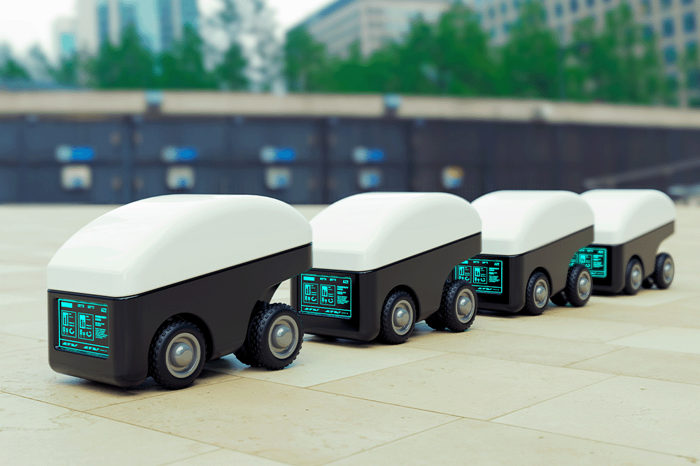 A line of small autonomous delivery robots moving outdoors in an urban environment.