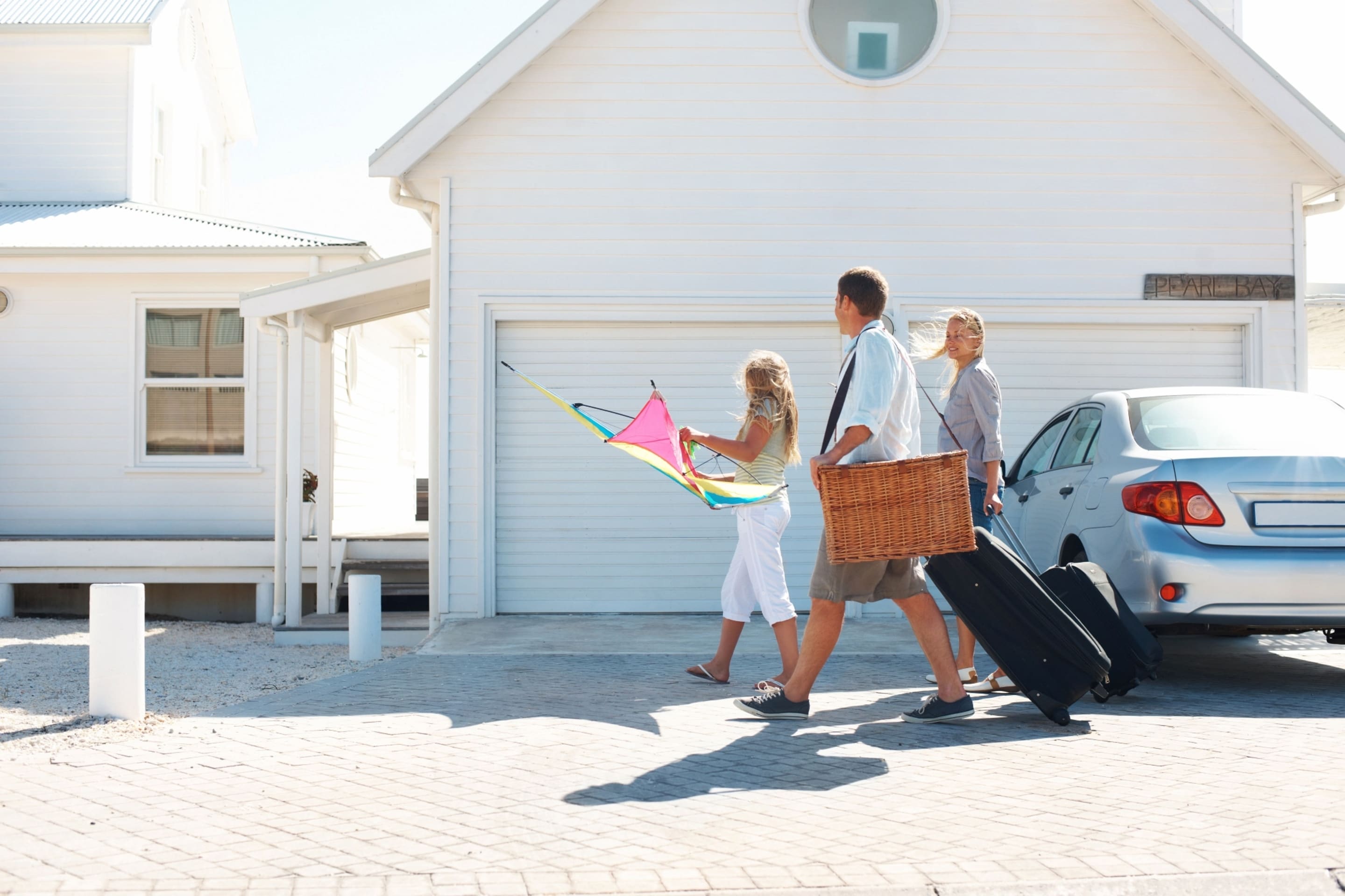 白い家に向かって車道を歩く家族