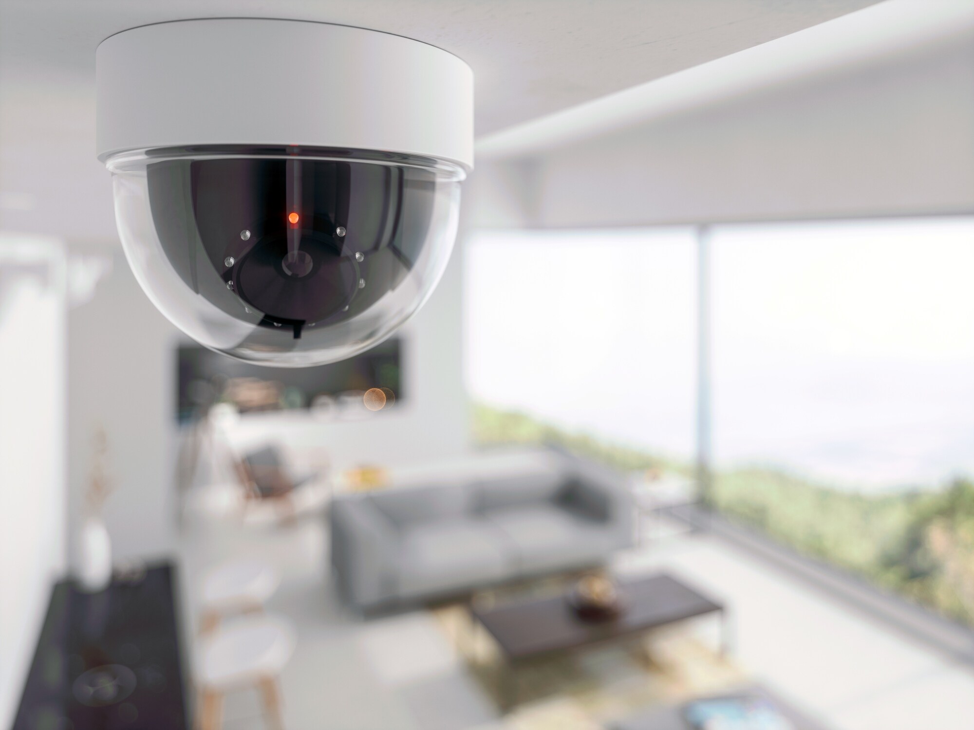 Ceiling-mounted security camera monitoring a bright modern living room.
