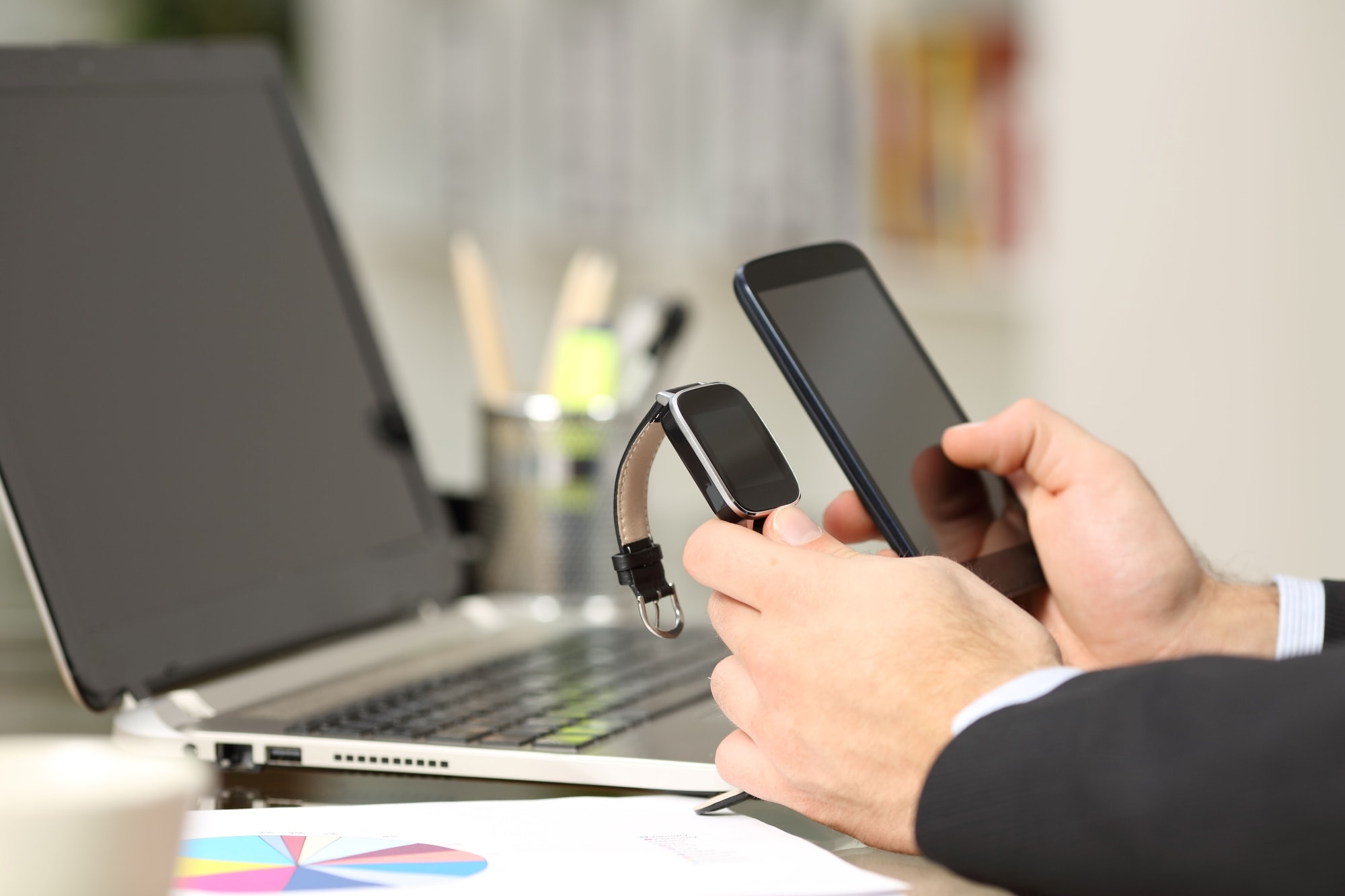 A person holding a smartphone and making a contactless payment using a handheld card reader. 