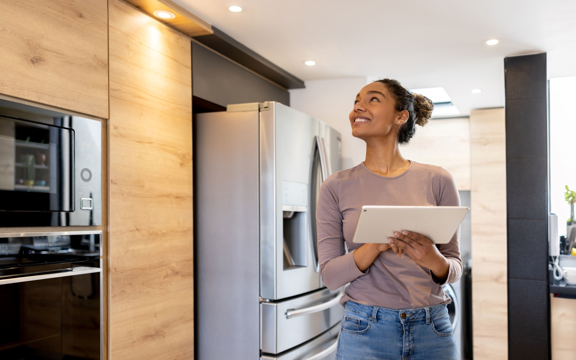 Woman controlling the lights of her smart house using an automated system.
