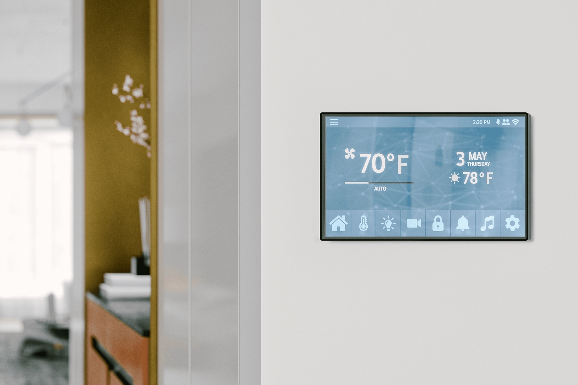 Bright modern hallway with a wall-mounted smart home touchscreen displaying temperature and controls, opening into a contemporary living area in the background.