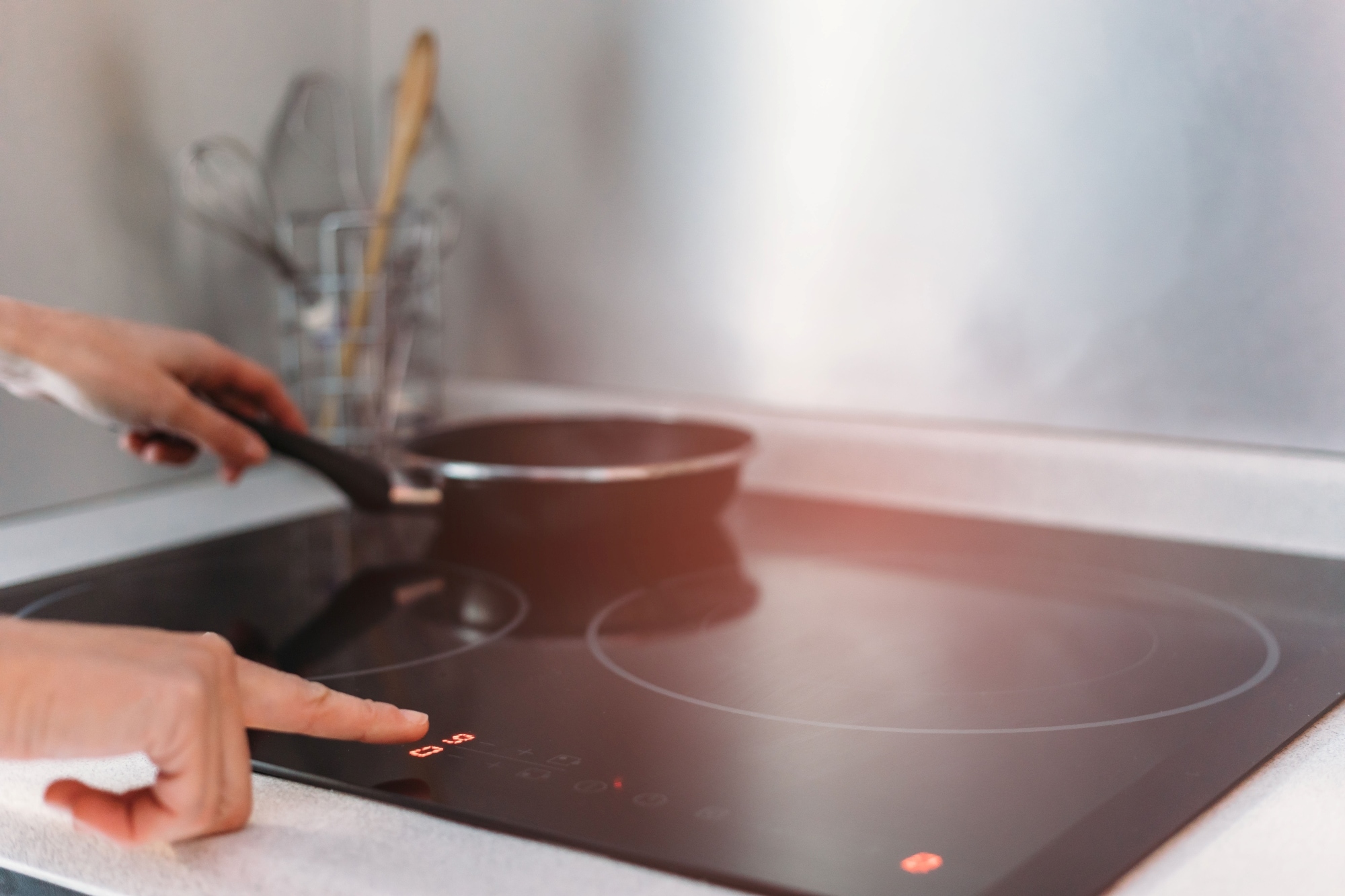 Close up of woman using induction stove in kitchen