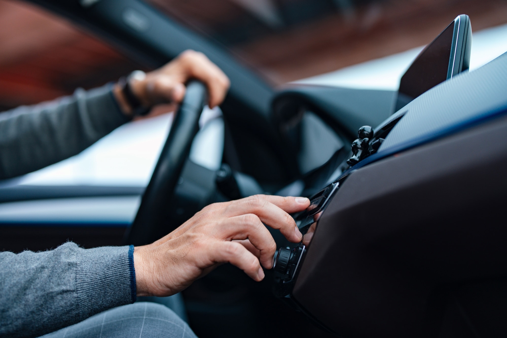 Image of a person wearing a smartwatch on their wrist while their hands are partially submerged in a swimming pool, with sunlight creating ripples and reflections on the water's surface. 