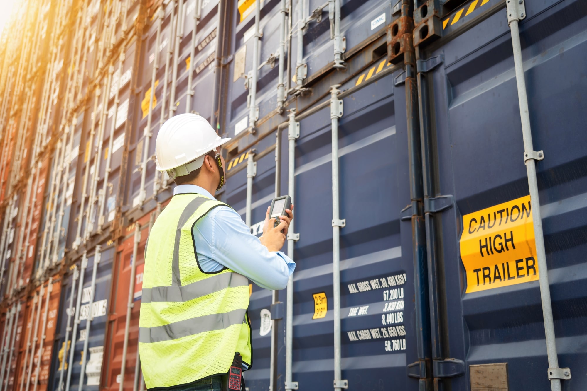 Image of a person wearing a smartwatch on their wrist while their hands are partially submerged in a swimming pool, with sunlight creating ripples and reflections on the water's surface. 