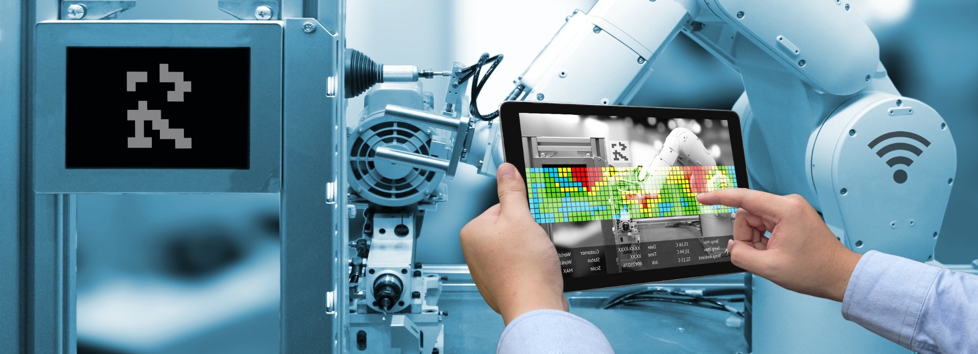 Engineer monitoring and controlling a robot arm through a tablet
