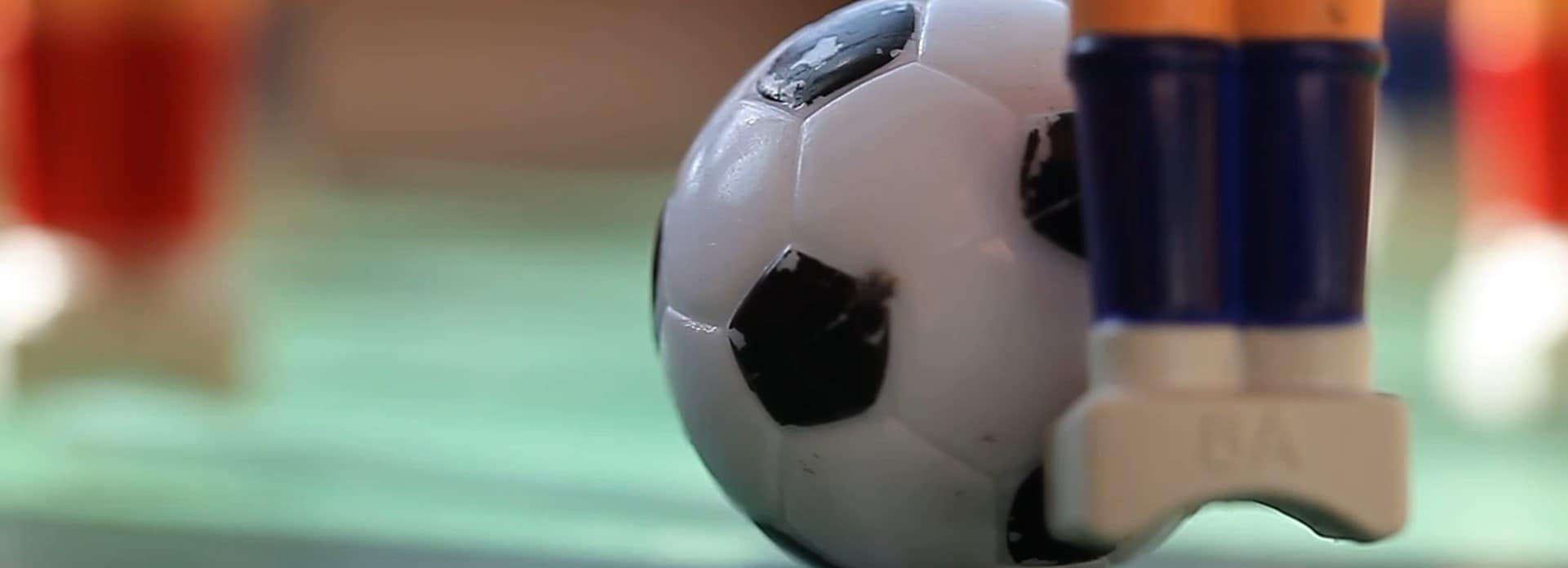 Zoom of table football game with the ball at the feet of the plastic figure