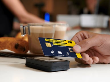 someone paying with biometric payment card, coffee cups in the background